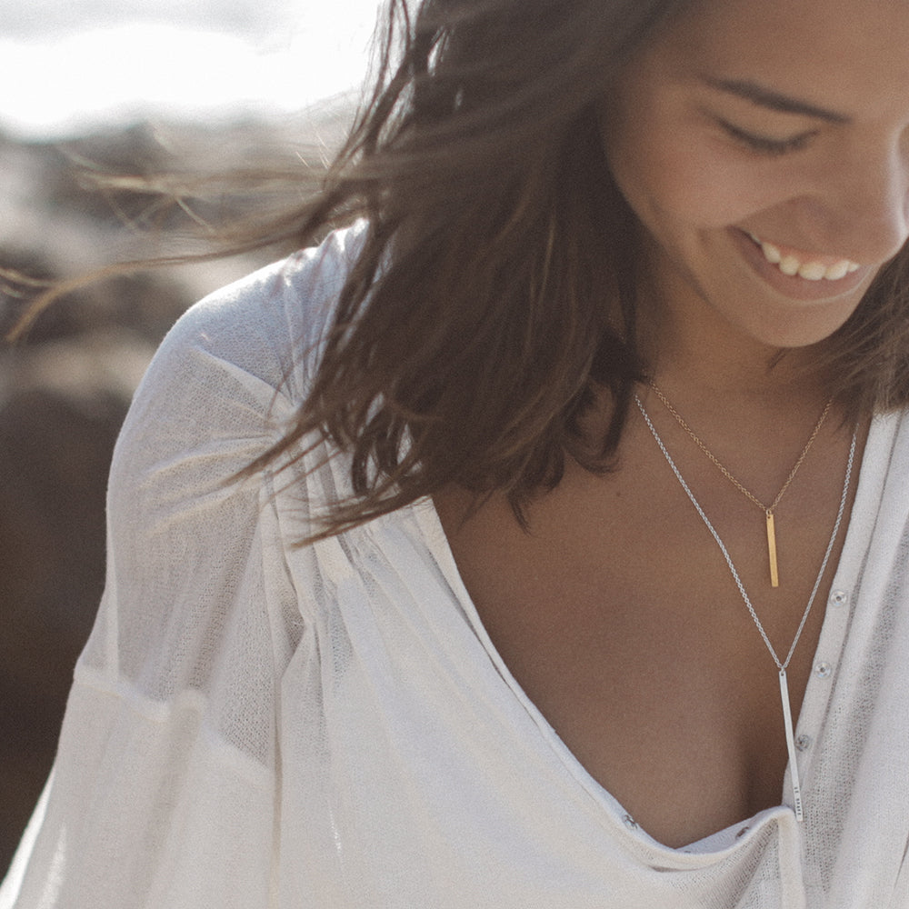 layered vertical bar necklaces on model