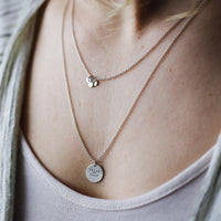 layered mini coin and seedling necklaces on model