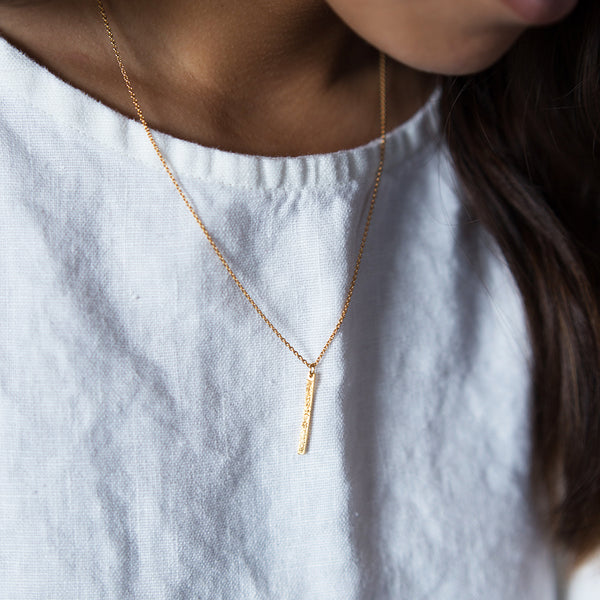 gold diamond dusted mini bar necklace on model