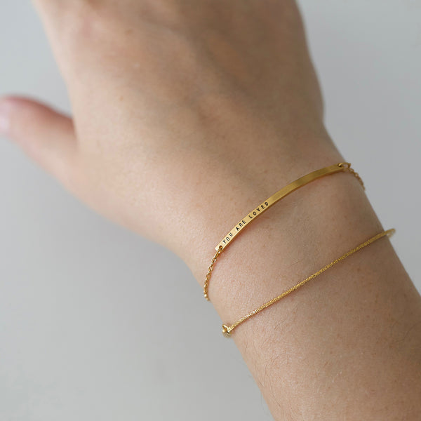 thin gold bar bracelet on wrist